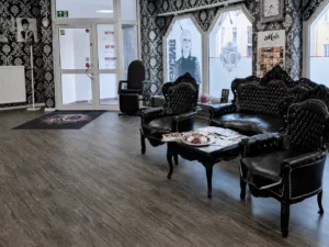 Wartebereich mit schwarzer Sitzgruppe im P.ink Tattoo & Piercing Studio Neustadt bei Coburg